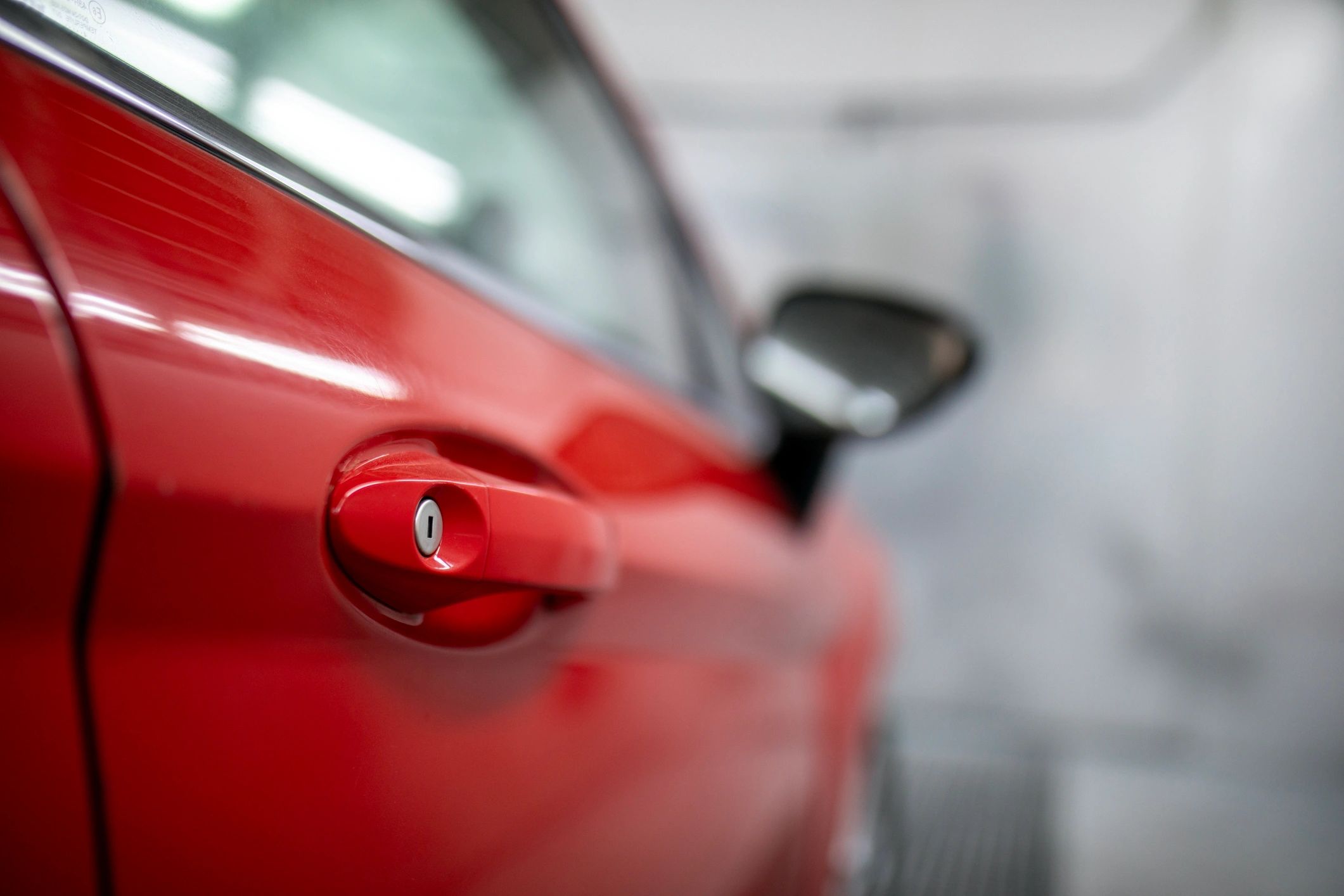 Red vehicle door handle close-up showing clean panel detail